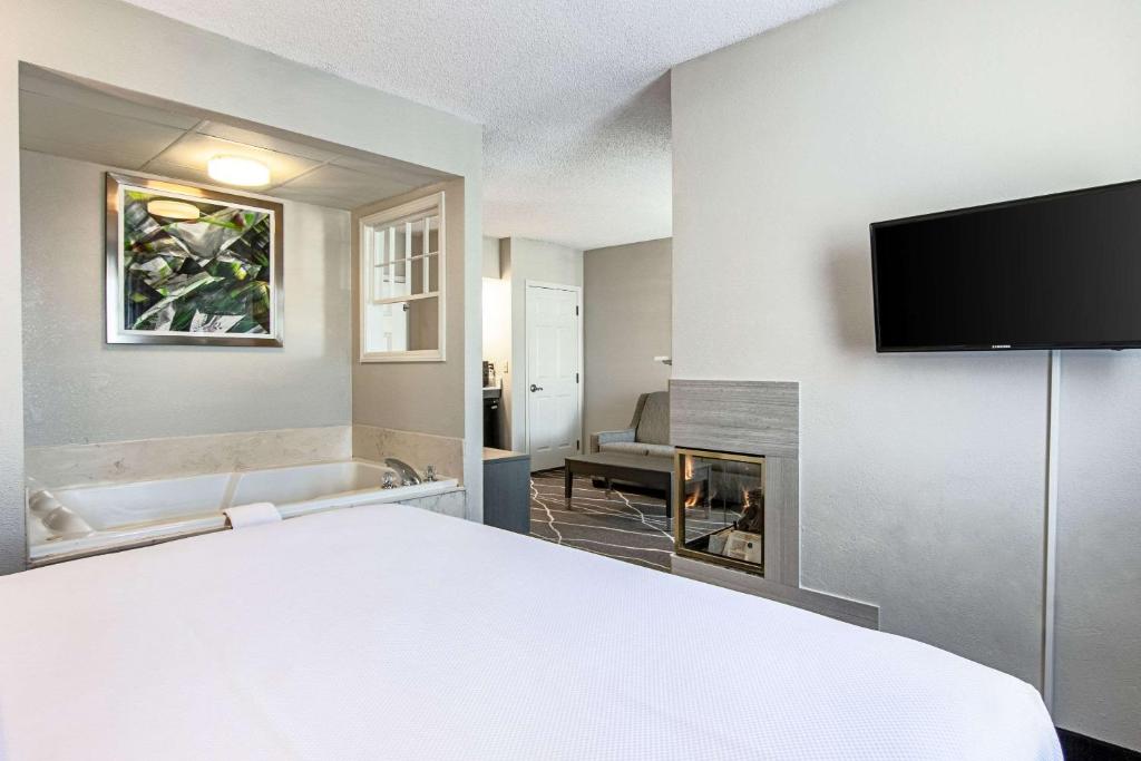 a hotel room with a bed and a flat screen tv at Clarion Inn Willow River in Sevierville