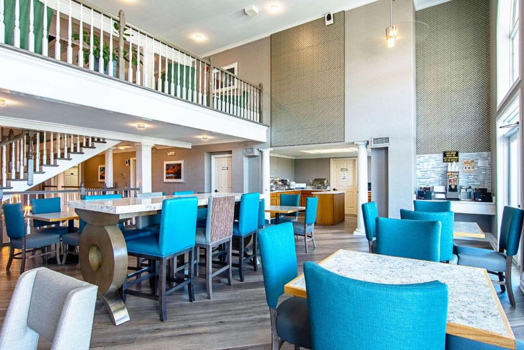 a dining room with blue chairs and tables at Clarion Inn Willow River in Sevierville