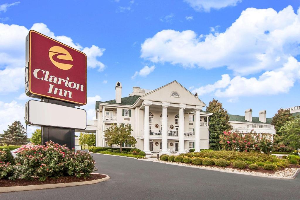 a sign in front of a building with a mansion at Clarion Inn Willow River in Sevierville
