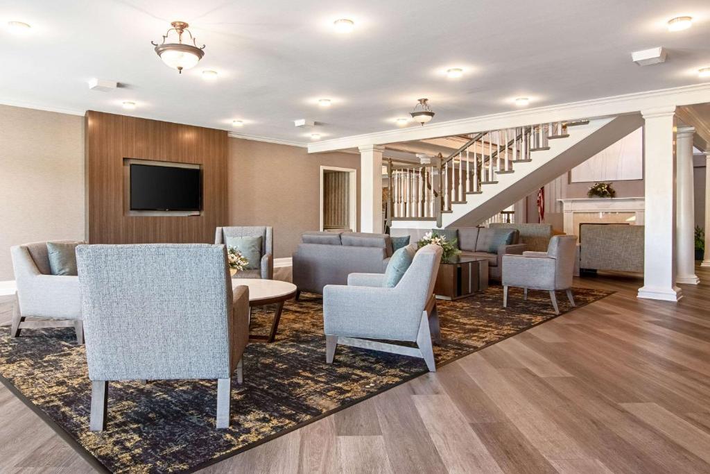 a lobby with a waiting room with chairs and a tv at Clarion Inn Willow River in Sevierville