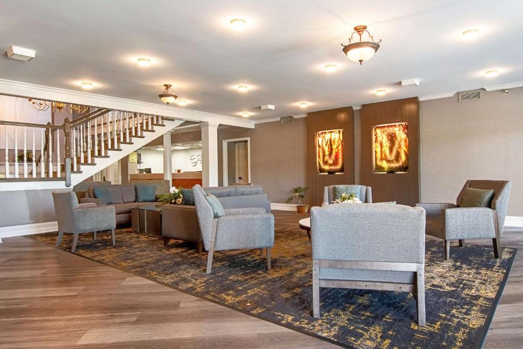 a lobby with couches and chairs and a staircase at Clarion Inn Willow River in Sevierville