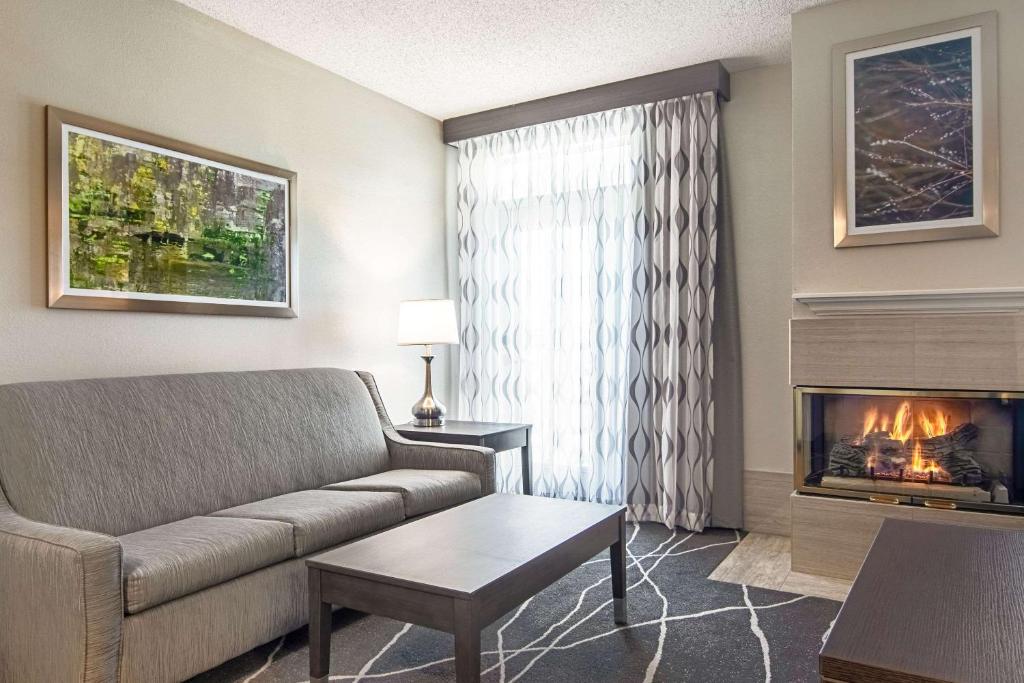 a living room with a couch and a fireplace at Clarion Inn Willow River in Sevierville