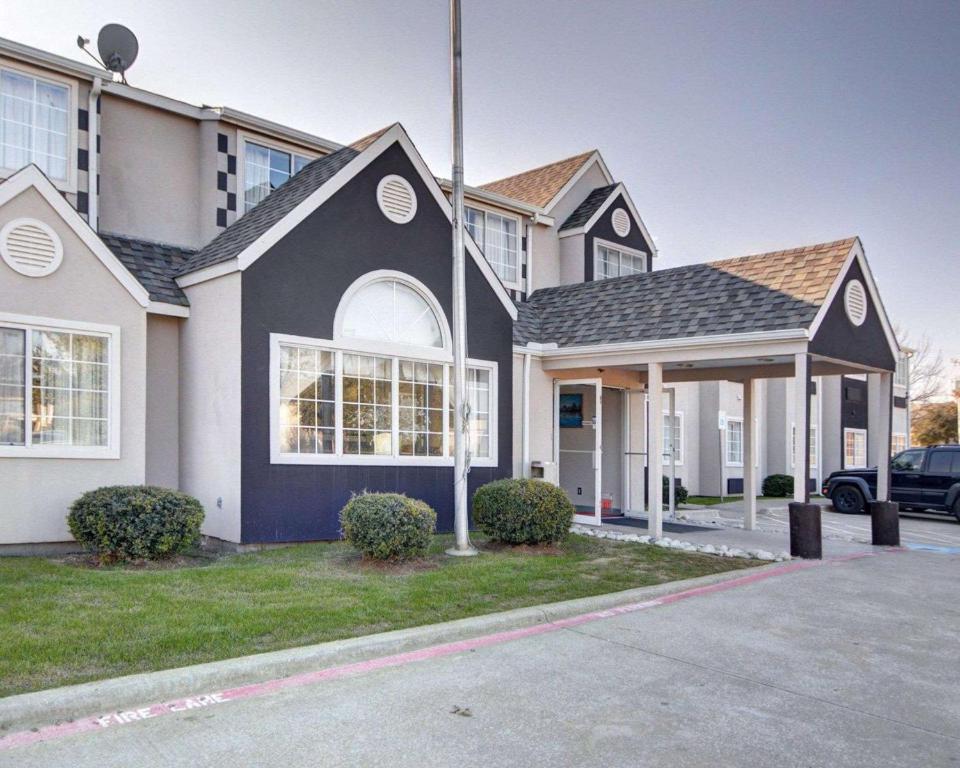 a house with a black and white at Rodeway Inn & Suites Lewisville I-35 in Lewisville