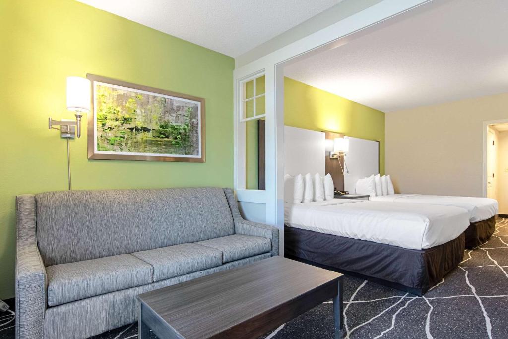 a hotel room with a bed and a couch at Clarion Inn Willow River in Sevierville