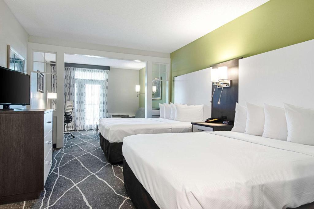 a hotel room with two beds and a flat screen tv at Clarion Inn Willow River in Sevierville