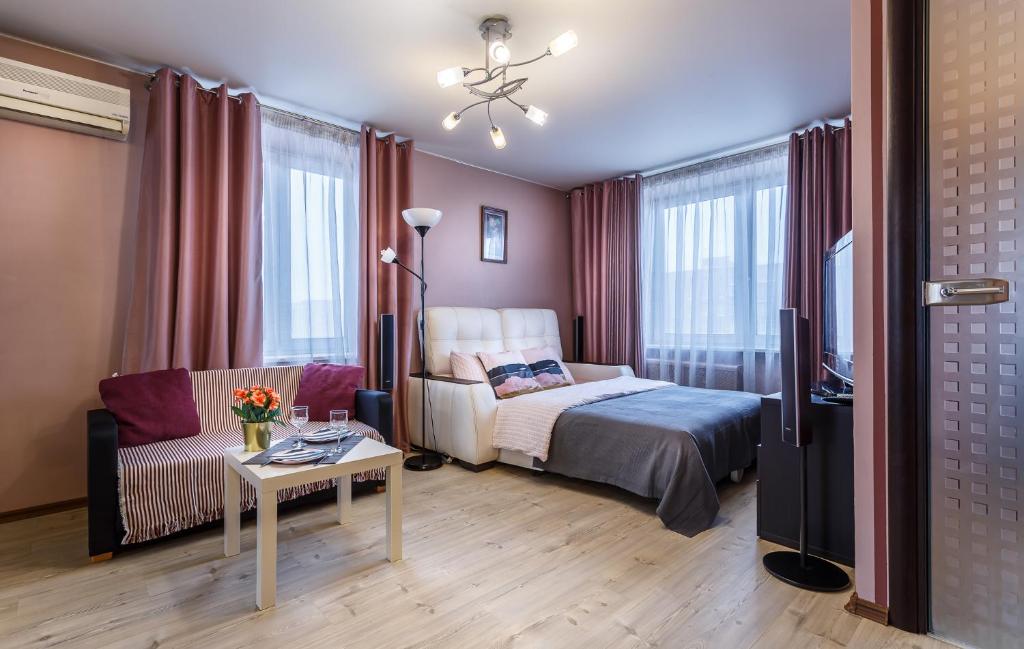 モスクワにあるБУТЫРСКАЯ 9 - м САВЕЛОВСКАЯのベッドルーム1室(ベッド1台、ソファ、テーブル付)