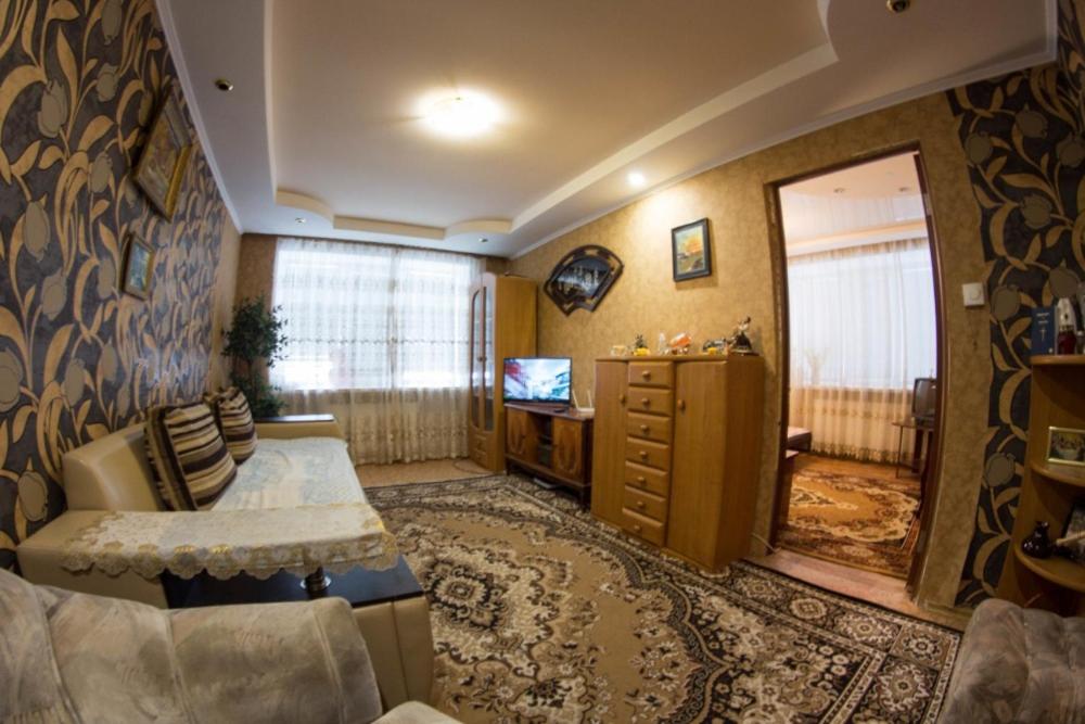 a living room with a couch and a tv in a room at 58 вулиця Яновського in Kropyvnytskyi