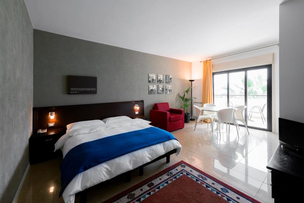 1 dormitorio con 1 cama grande, mesa y sillas en Residence Annunziata, en Messina