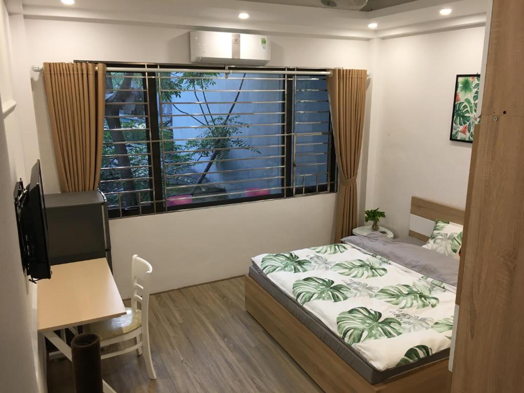 1 dormitorio con cama y ventana grande en N&D Happy House- Studio Apartment - Phong tieu chuan khach san, bep nau va nha ve sinh trong khuon vien en Hanói
