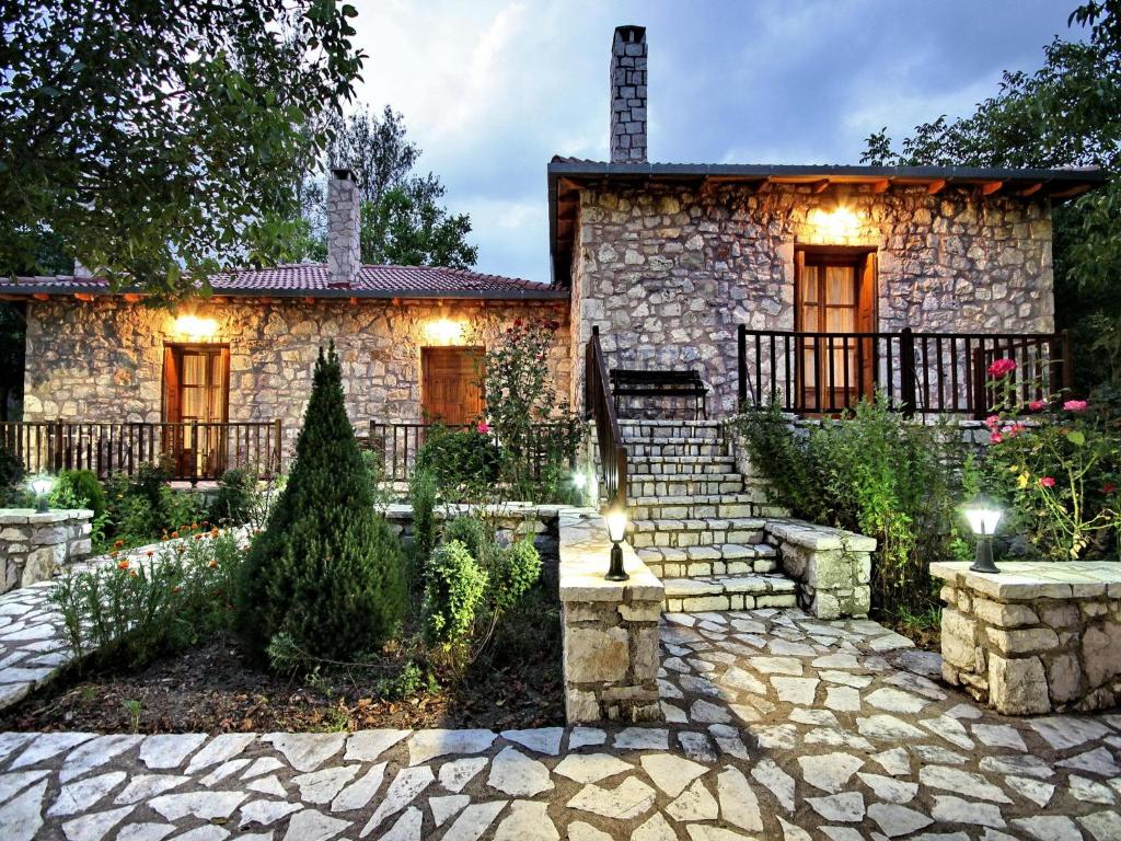 a stone house with a stone path in front of it at Andrea Sofi Guesthouse in Dhimitsana