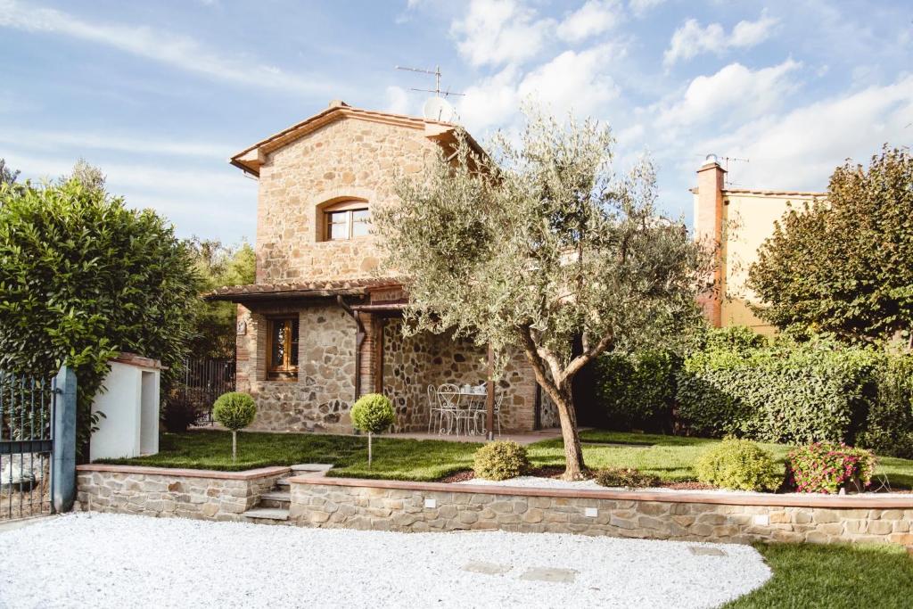 una casa in pietra con un albero di fronte di Il Fienile di Tigliano a Vinci