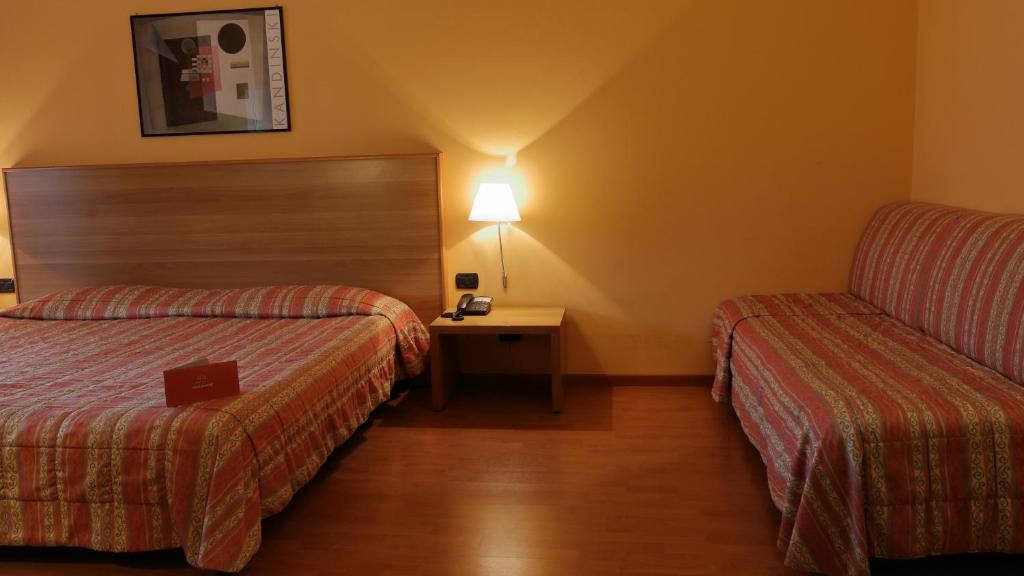Postel nebo postele na pokoji v ubytování Hotel Romanisio