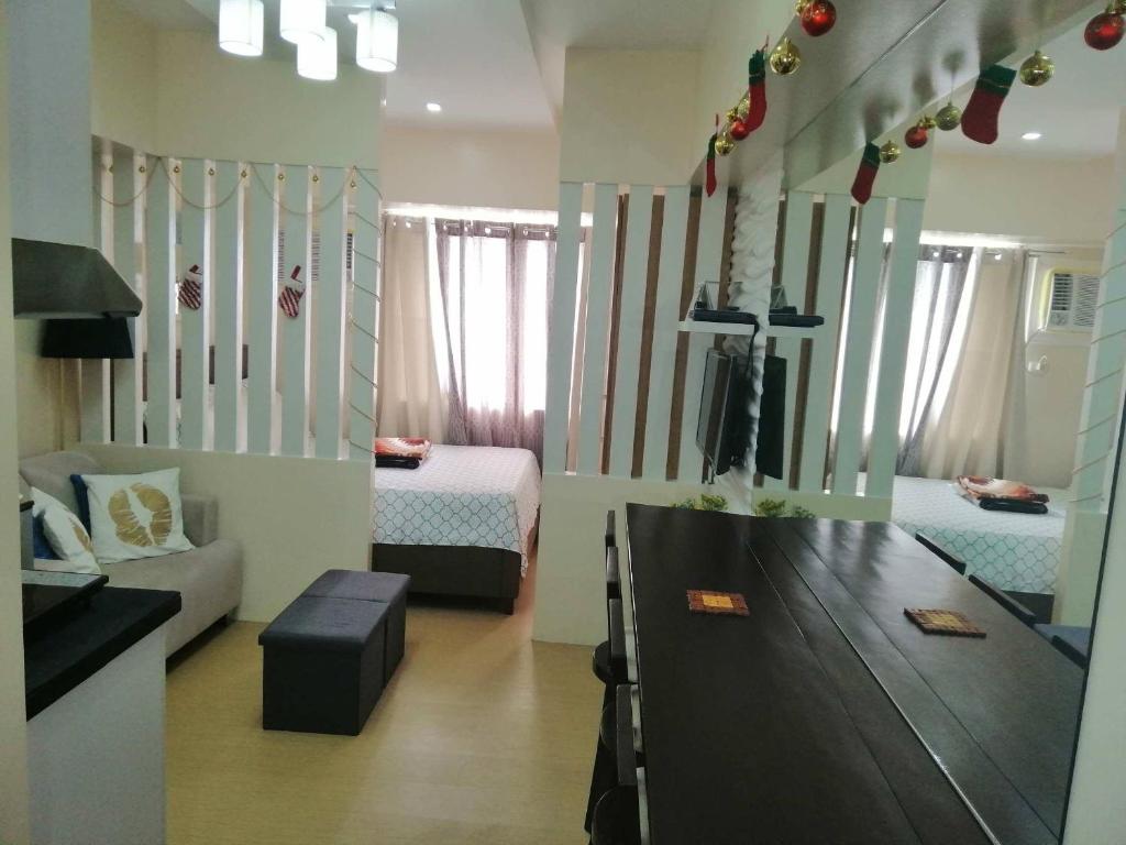 ein Wohnzimmer mit 2 Betten und einem TV. in der Unterkunft Cozy Studio Unit at Davao City Downtown Area in Davao City