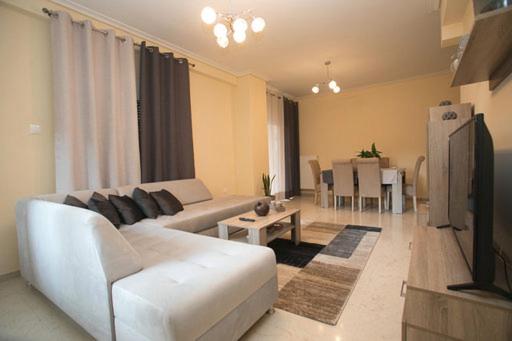アテネにあるAthenian Riviera Apartmentのリビングルーム(白いソファ、テレビ付)