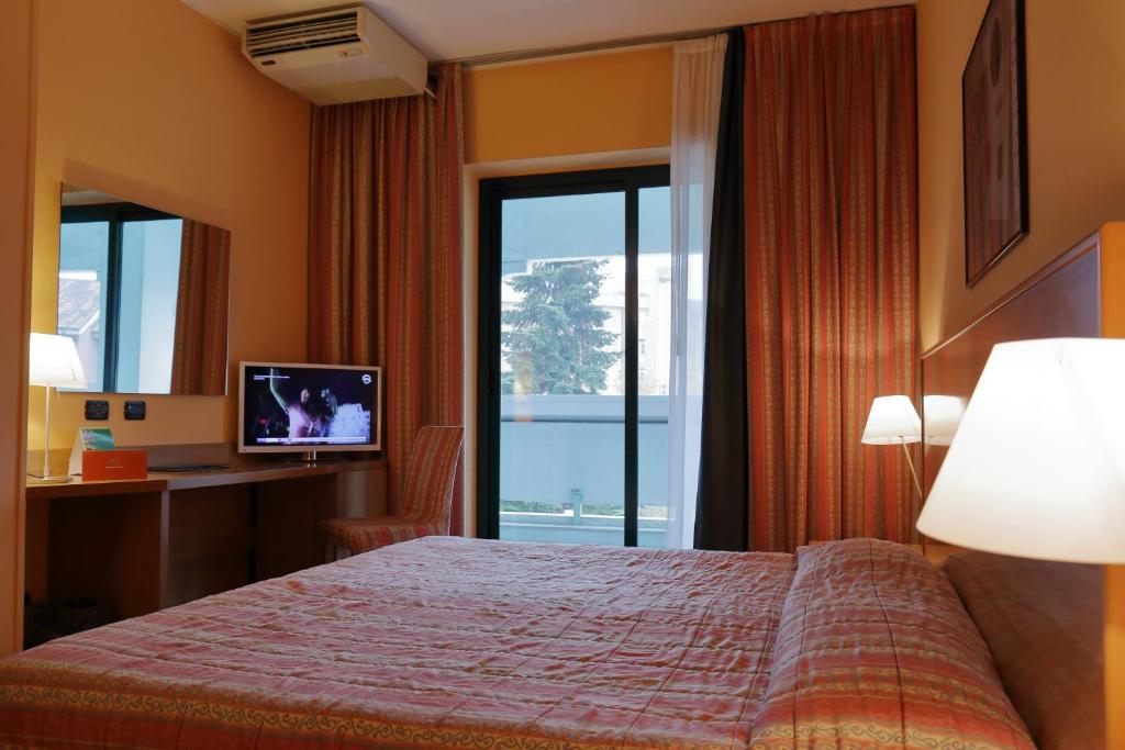 a hotel room with a bed and a window at Hotel Romanisio in Fossano