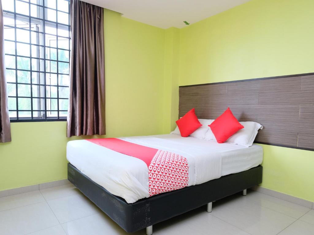 a bedroom with a large bed with red pillows at Hotel De' Tees, Masai Utama in Pasir Gudang