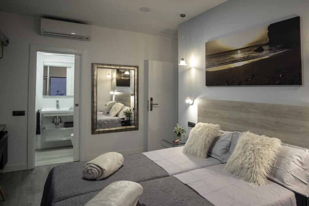 a bedroom with a large bed and a bathroom at La Palmera Hotel Boutique in Las Palmas de Gran Canaria