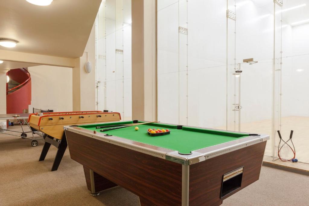 a room with a pool table and two tables at The Originals City, H&ocirc;tel Le Forum, Strasbourg Nord in Schiltigheim