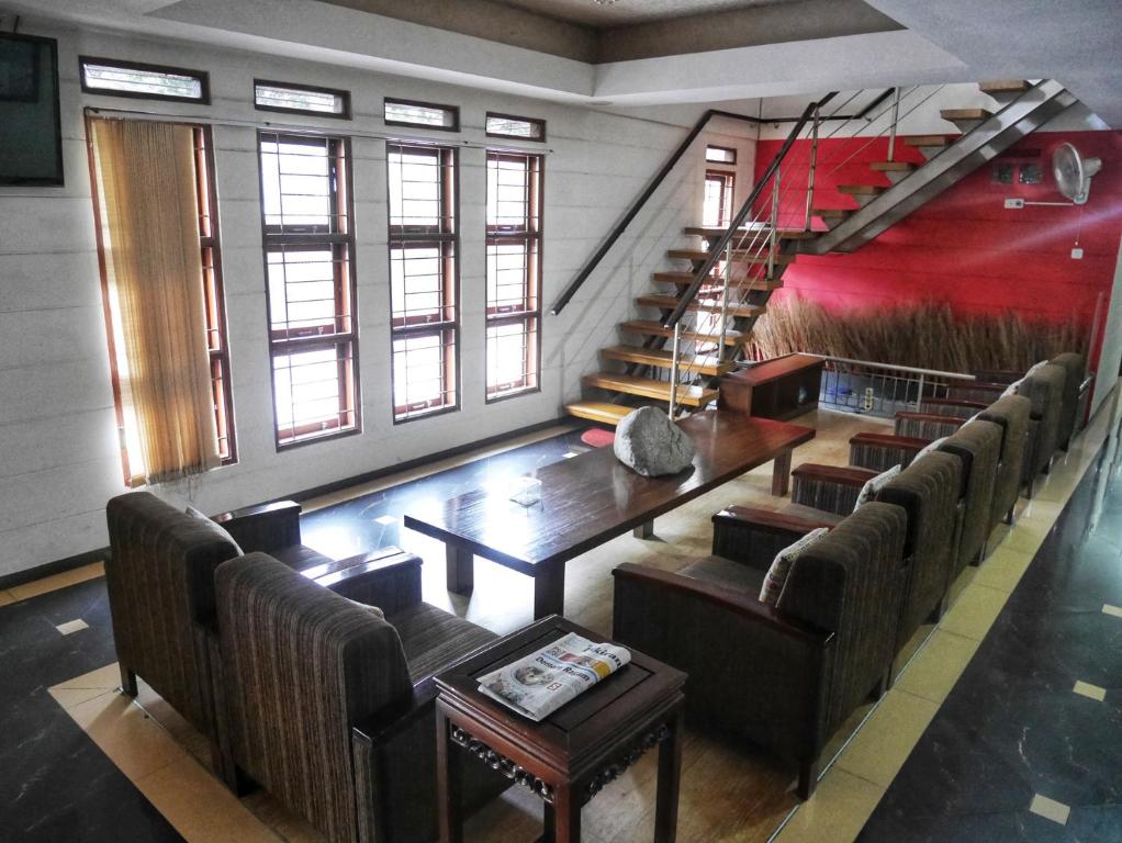 a room with a table and chairs and a staircase at Rumah Tawa Hotel Syariah in Bandung