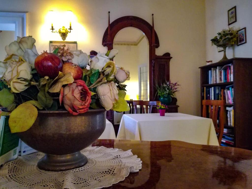 
a vase filled with flowers on top of a table at Hotel Casa Mia in Syracuse
