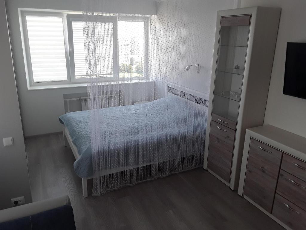 LBE apartments في نارفا: غرفة نوم بيضاء بها سرير ونافذة