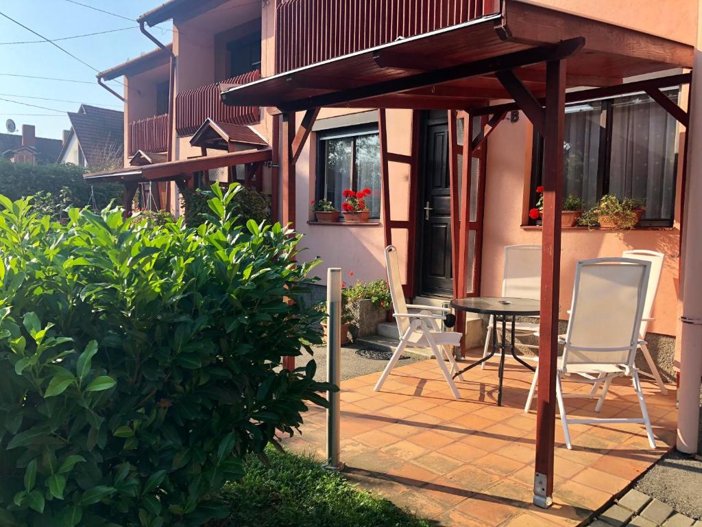 un patio con sillas y una mesa frente a una casa en RT Home Vendégház en Szombathely