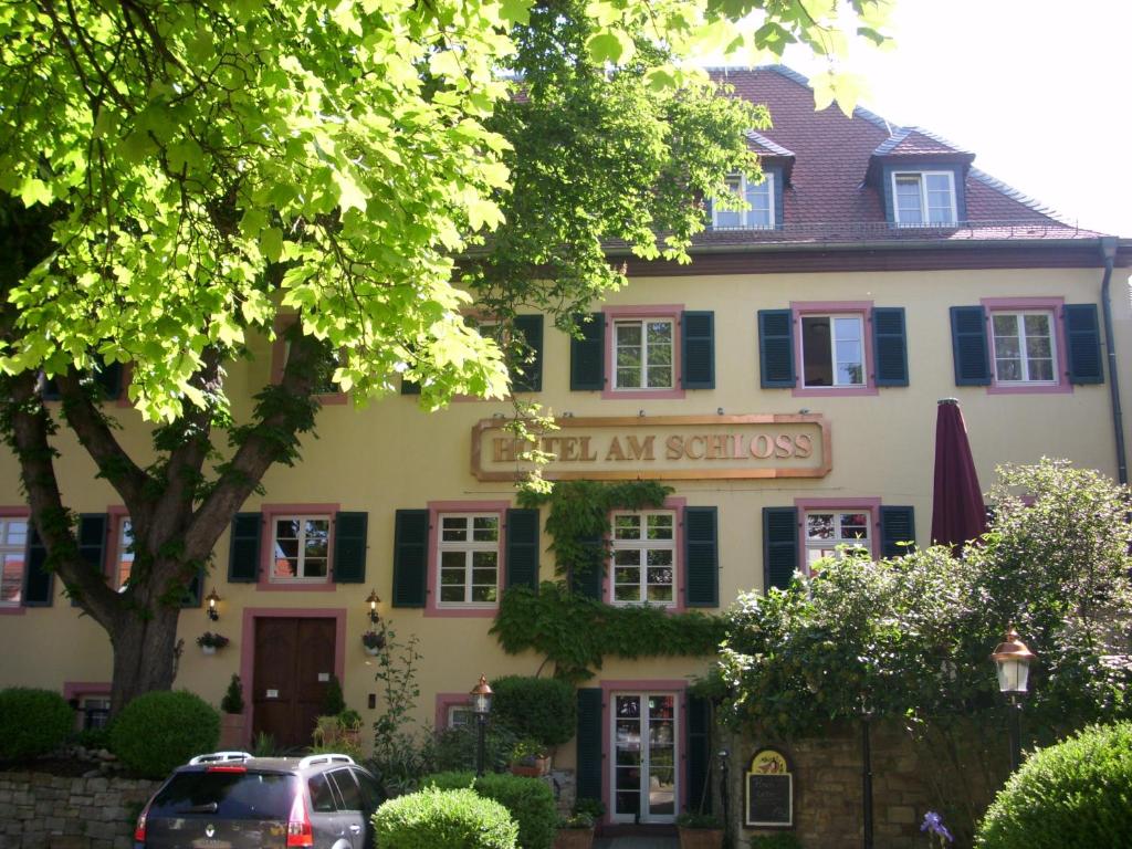 Hotel Am Schloss في آلتزي: مبنى متوقف امامه سيارة