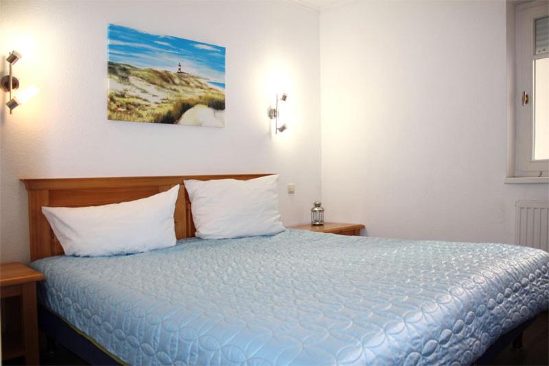 キュールングスボルンにあるFewo-Perner Sonnenburgのベッドルーム1室(青いベッド1台、枕2つ付)