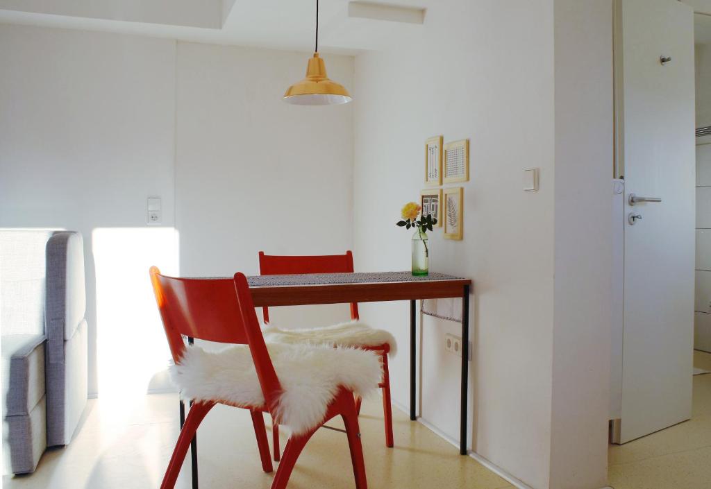 mesa de comedor con silla roja y escritorio en Gemütliche Stadtwohnung in Schwäbisch Hall, en Schwäbisch Hall