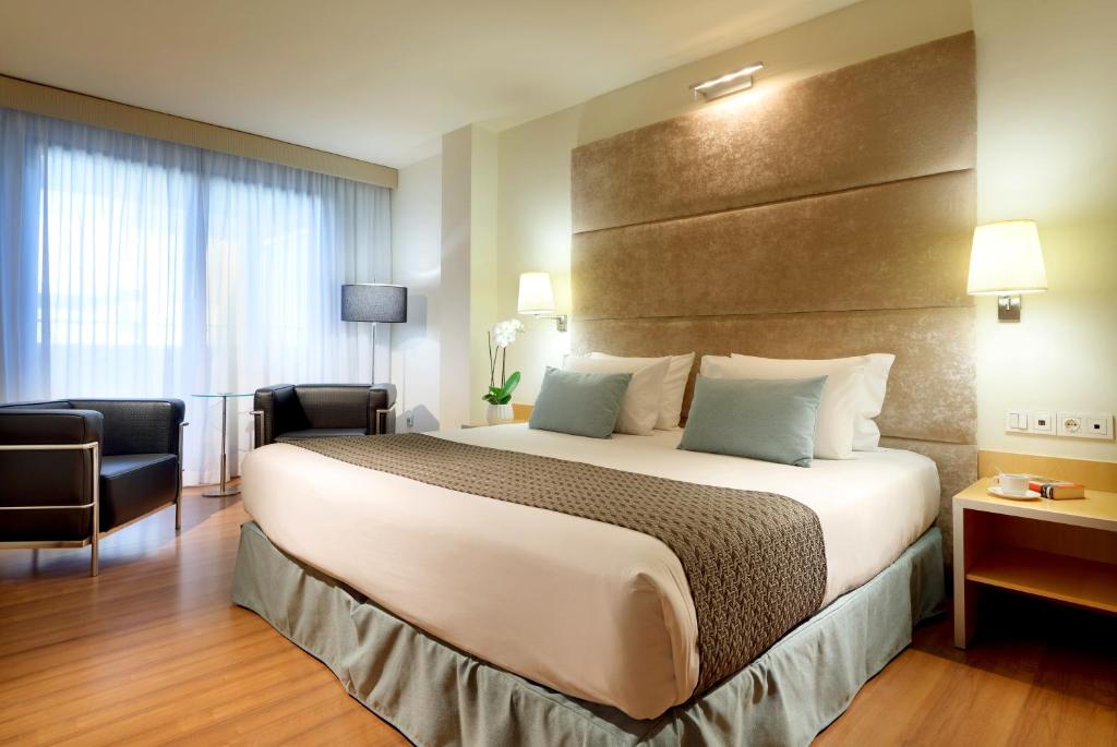 una habitación de hotel con una cama grande y una silla en Eurostars Centrum Alicante en Alicante