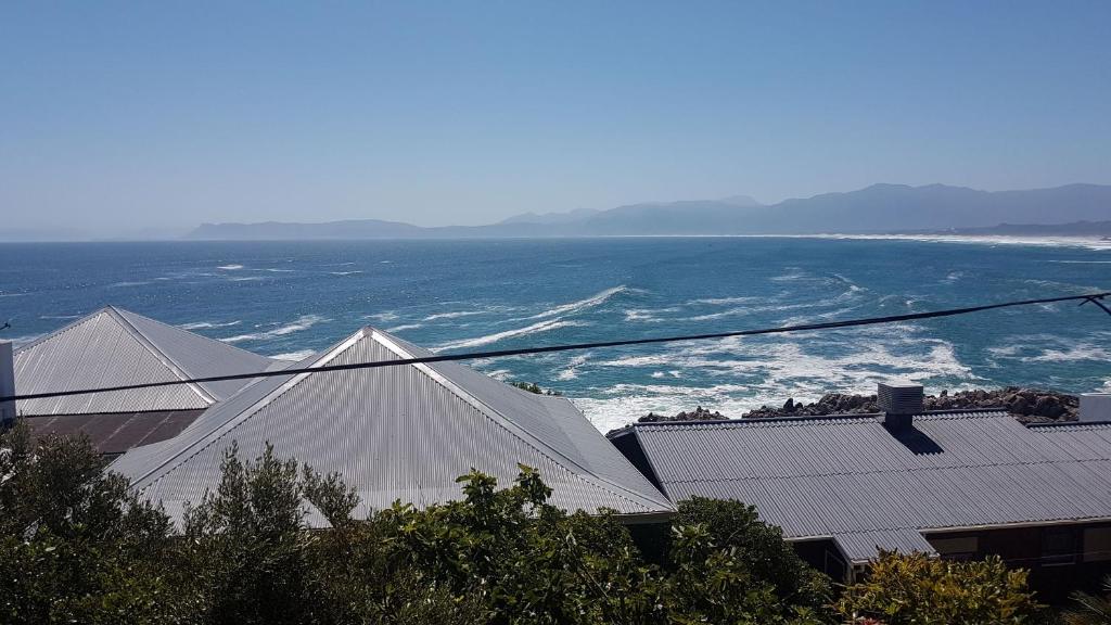 a view of the roofs of buildings and the ocean at Amazing Grace B&B in Gansbaai