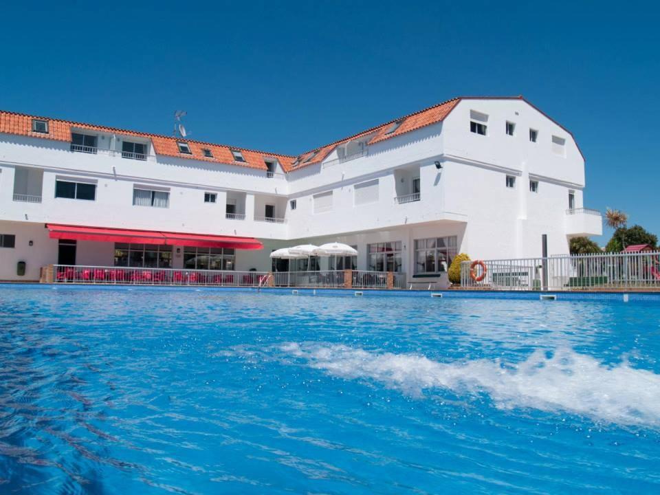 un gran edificio blanco con una gran piscina en Camping Playa América, en Playa América
