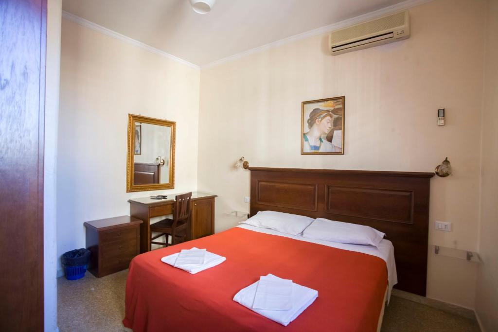 a bedroom with a bed and a desk and a mirror at Via Curtatone 12 Stazione Termini in Rome