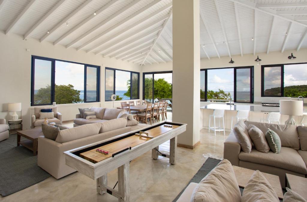 uma sala de estar com sofás e uma mesa em Sandcastle Beach House em The Valley