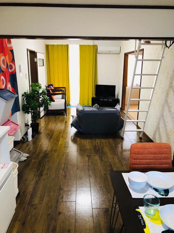 a living room with a bed and a ladder at 201Keiko's Home 大空間2LDKロフト付きfree parking in Kasugabaru