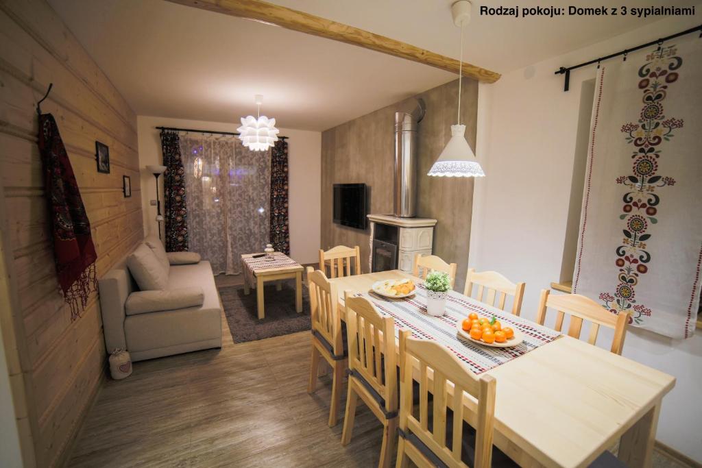 a kitchen and dining room with a table and chairs at Urocze domki Zakopane in Zakopane