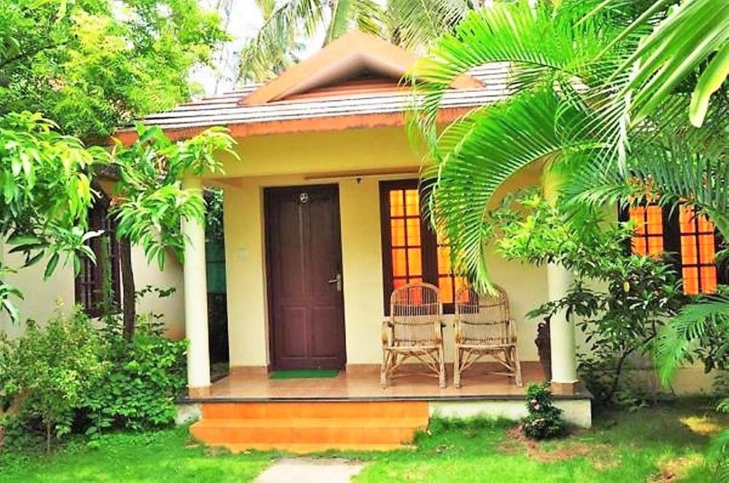 a small house with two chairs on a porch at Sea Star Beach Homes in Cherai Beach