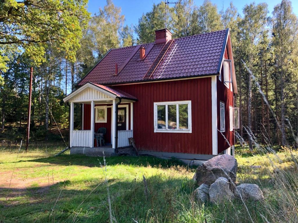 a red tiny house in the middle of a field at Ferienhaus Småland in Fågelfors