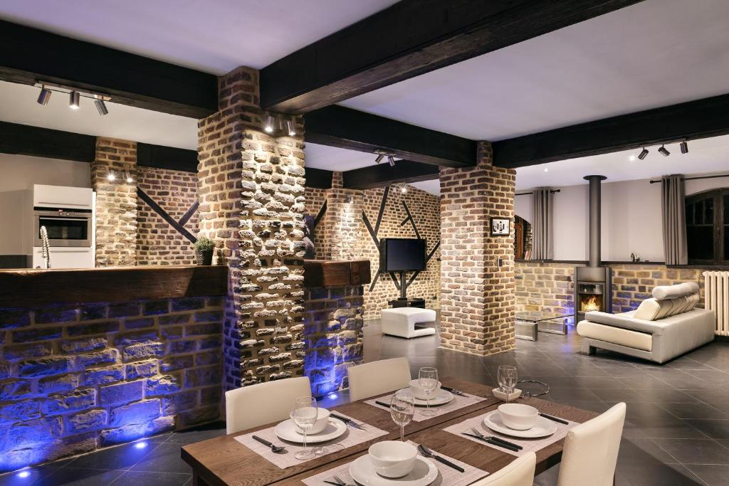 uma sala de estar com uma mesa de jantar e uma parede de tijolos em Appart-Hotel Léopold Liège Centre em Liège