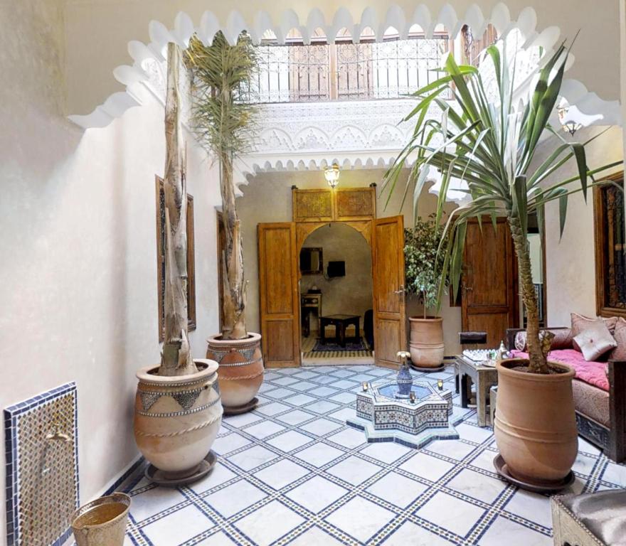 a living room with potted plants on a tiled floor at Riad abaka by ghali 2 in Marrakesh