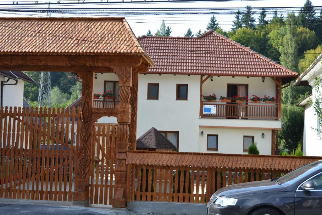 a house with a wooden fence and a wooden gazebo at Casa Bunicii in Moisei