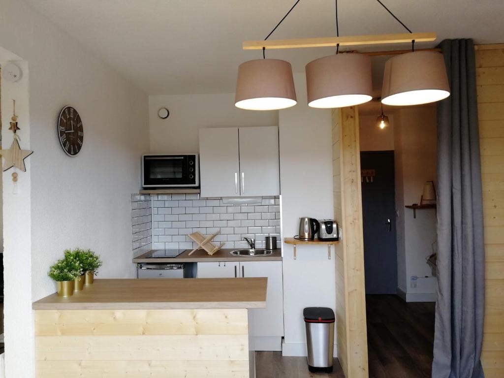 a kitchen with white cabinets and a counter top at Bel appartement cosy - PIED DES PISTES avec local à ski - 6 personnes in Montclar