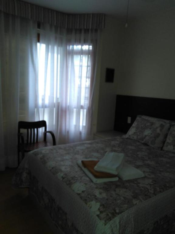 - une chambre avec un lit, un plateau et une fenêtre dans l'établissement Apartamento Centro Gramado, à Gramado