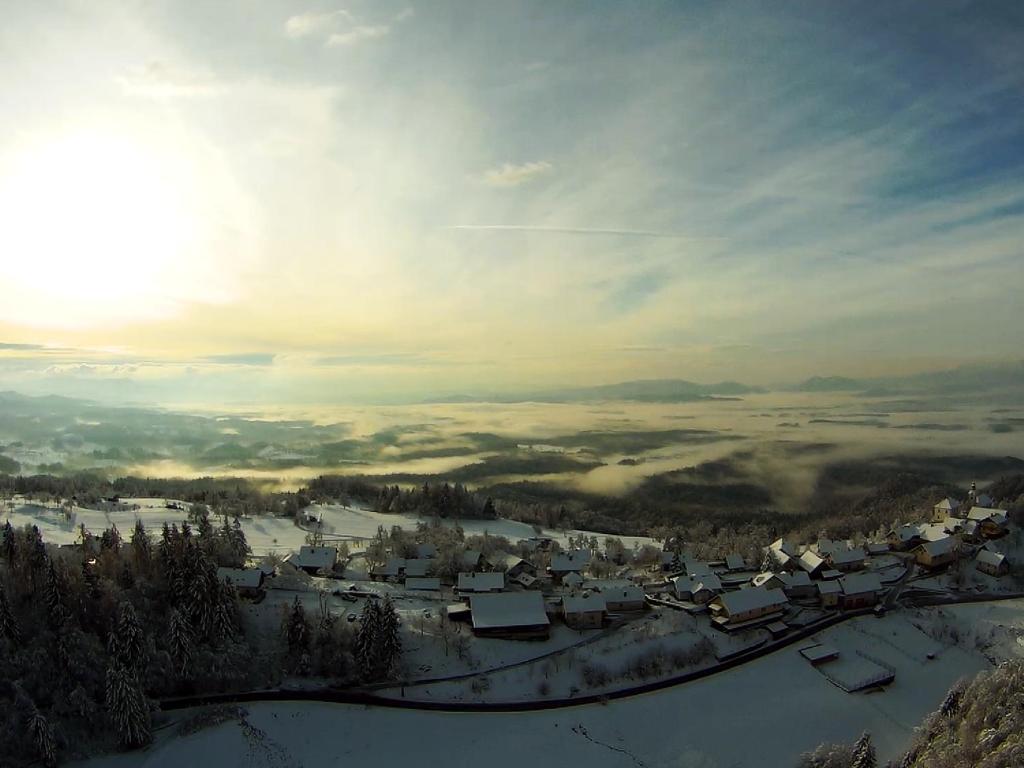 un pueblo en la nieve con el sol en el cielo en Turizem Pavlin Apartments, en Šenturska Gora