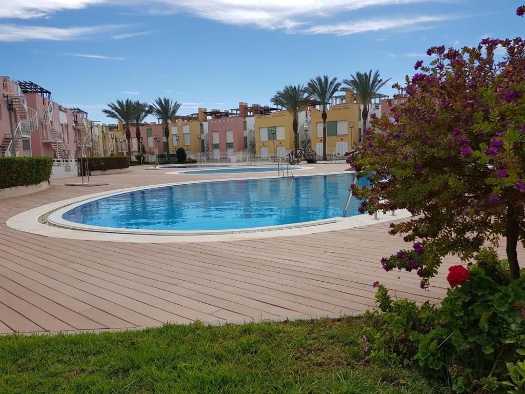 una gran piscina con palmeras y edificios en Vera Playa Laguna Beach Resort, en Vera