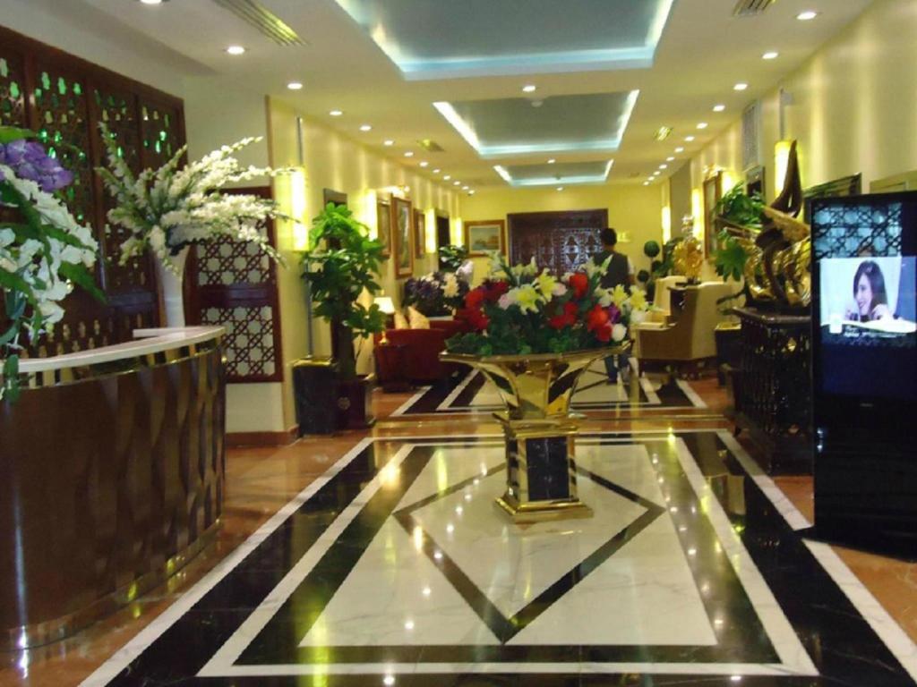 a lobby with a vase of flowers on a table at Oasis Hotel in Alger
