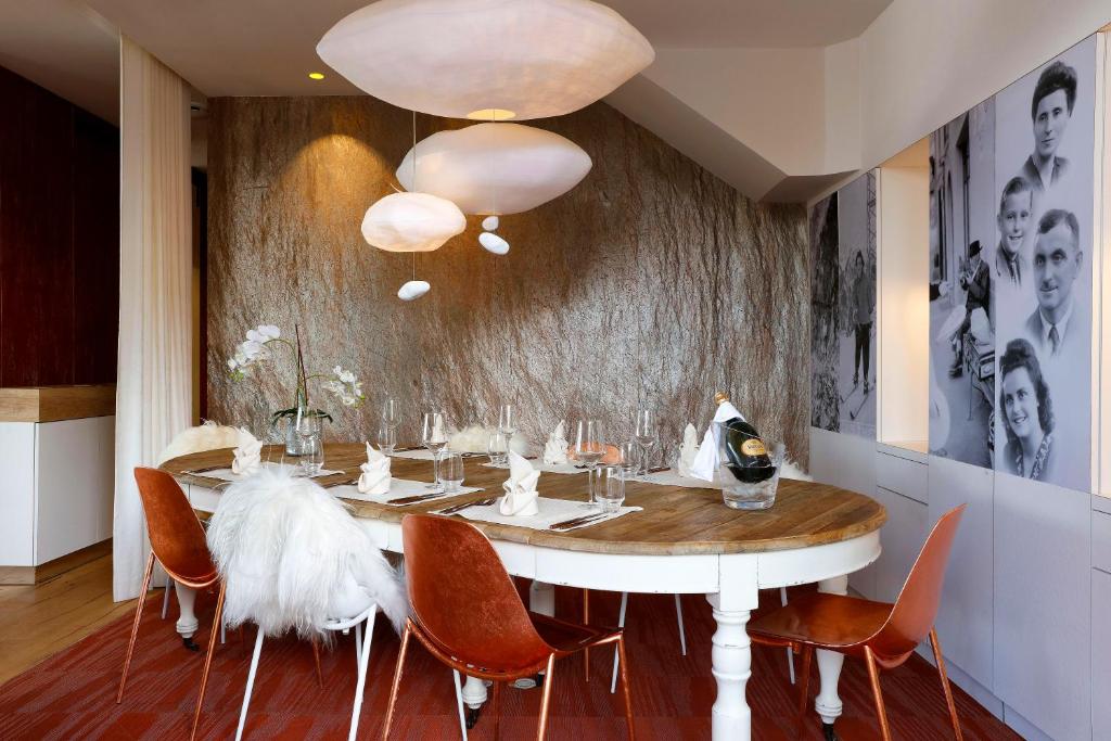 a dining room with a white table and chairs at Grandes Rousses Hotel & Spa in L'Alpe-d'Huez