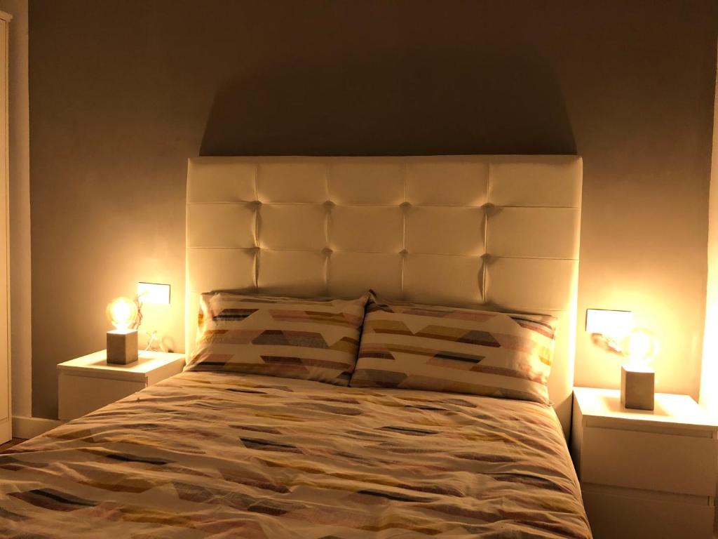 a bedroom with a large white bed with two lamps at Plaza del Campo del Príncipe in Granada