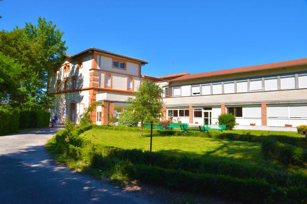 un gran edificio con un patio de césped junto a una carretera en Centre Louis Ormières, en Montauban