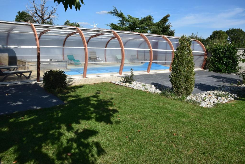 a swimming pool in a garden with a building at Les Chènevottes au Hameau 1936 in Cherveux